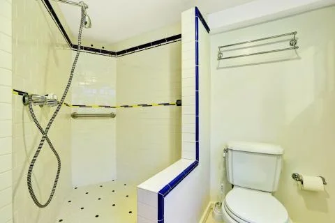 Interior of white bathroom with large walk-in shower and a toilet. Stock Photos