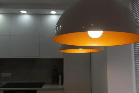 Interior. White kitchen in a modern style. Beautiful lighting in the kitchen. Stock Photos