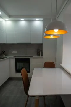 Interior. White kitchen in a modern style. Beautiful lighting in the kitchen. Stock Photos