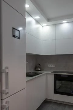 Interior. White kitchen in a modern style. Beautiful lighting in the kitchen. Stock Photos