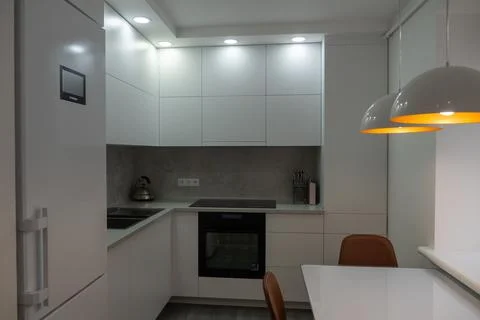 Interior. White kitchen in a modern style. Beautiful lighting in the kitchen. Stock Photos