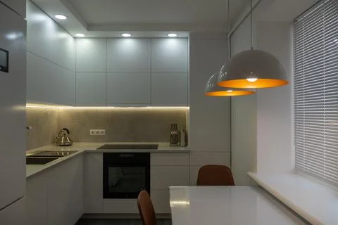 Interior. White kitchen in a modern style. Beautiful lighting in the kitchen. Stock Photos