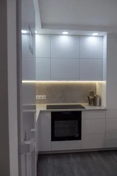 Interior. White kitchen in a modern style. Beautiful lighting in the kitchen. Stock Photos