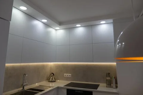 Interior. White kitchen in a modern style. Beautiful lighting in the kitchen. Stock Photos