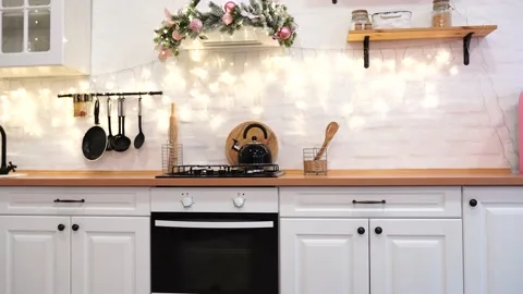 Interior of white kitchen with pink decorated Christmas garlands. Video stock 144997696