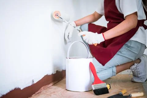 Interior working, Painter hand in white glove painting wall with paint roller Stock-Fotos