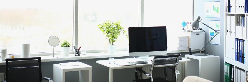 Interior of workplace with table, computer and large window Foto stock
