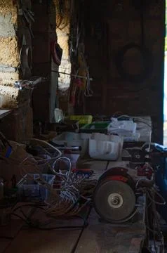 Interior of a workshop with various tools, cables, and equipment spread acr.. Stock Photos