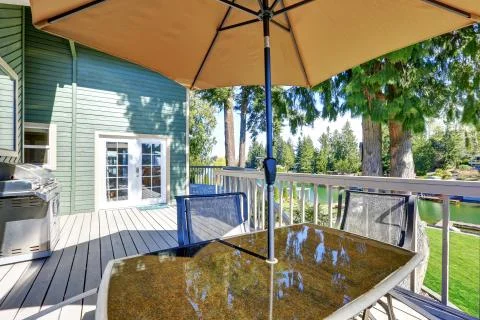 Interior of wraparound deck with table set and amazing view of Lake Tapps. Stock Photos