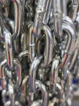 Interlinked silver metal chains in close-up view with reflective texture Stock Photos