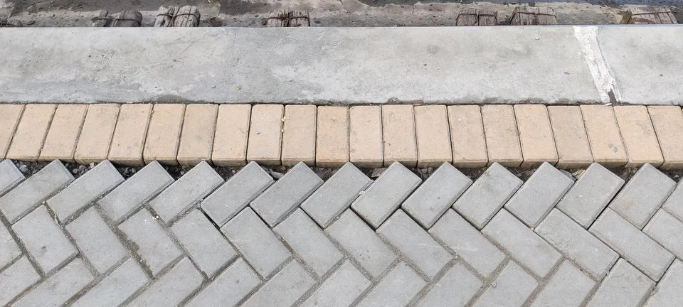 Interlocking bricks in herringbone pattern with concrete edging Foto stock