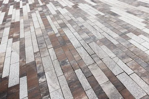 Interlocking brown and white paving stones forming a geometric pattern Stock Photos
