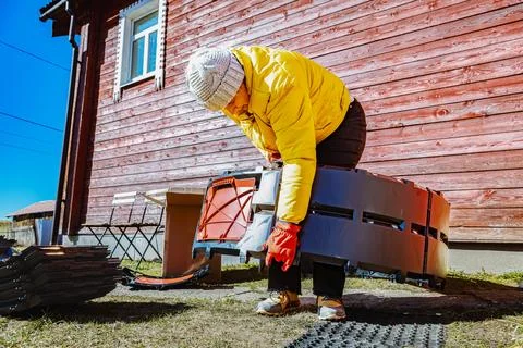 Interlocking compost bin panels being connected into circular structure by .. Stock Photos