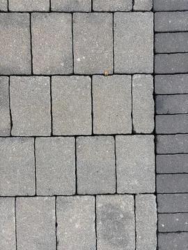 Interlocking concrete paver tiles in gray rectangular pattern with concrete Stock-Fotos