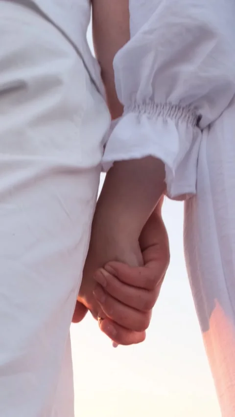 Interlocking Hands with a Shiny Engagement Ring Illuminated Against a Bright Stock Footage 306271440