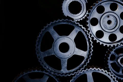 Interlocking industrial  cogwheels top view on black background Stock Photos