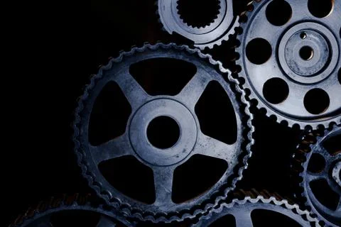 Interlocking industrial  cogwheels top view on black background Stock Photos