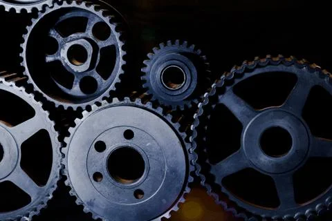 Interlocking industrial  cogwheels top view on black background Stock Photos