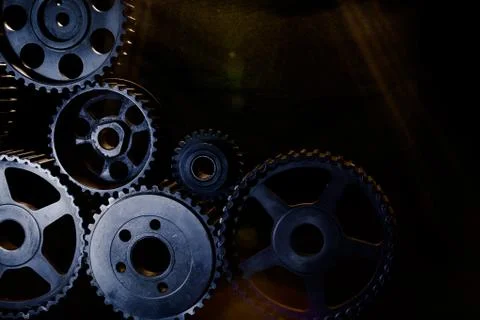 Interlocking industrial  cogwheels top view on black background Stock Photos