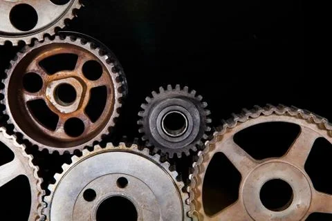 Interlocking industrial  cogwheels top view on black background Stock Photos