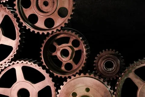 Interlocking industrial  cogwheels top view on black background Stock Photos