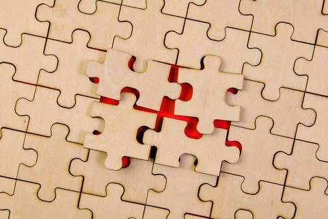 Interlocking Puzzle Pieces on Red Background: Strategy and Teamwork Concept Photos