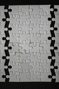 Interlocking White Puzzle Pieces on Black Background 스톡 사진