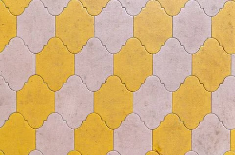 Interlocking yellow and beige tiles forming repeating pavement pattern 写真素材
