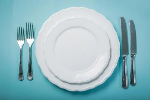 Intermittent fastin concept - empty plate on blue background Stock Photos