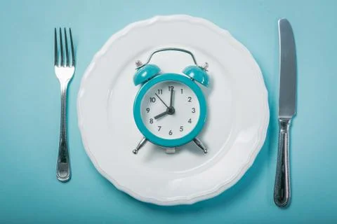 Intermittent fastin concept - empty plate on blue background Stock Photos
