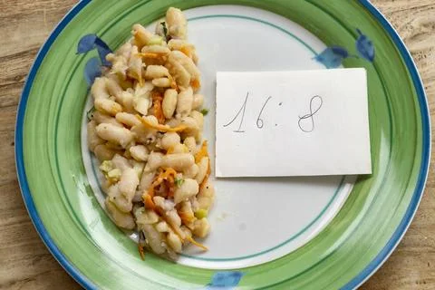 Intermittent fasting concept through plate of  bean salad and a note with 1.. Stock Photos