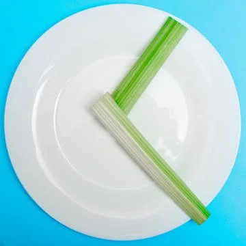 Intermittent fasting, diet concept. An empty plate as a dial and pods of a se 스톡 사진