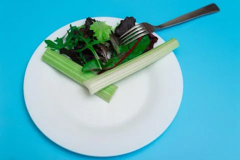 Intermittent fasting, diet concept. Figurative image of meal time. Fresh vege Stock Photos