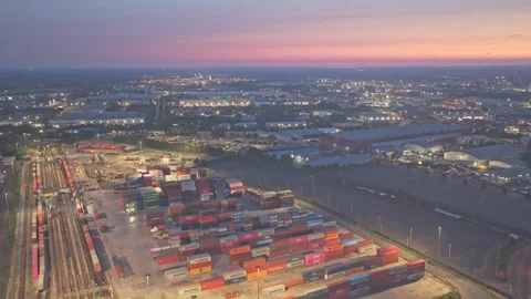 Intermodal freight container terminal and rail yard illuminated at dusk in Stock Footage 340560250