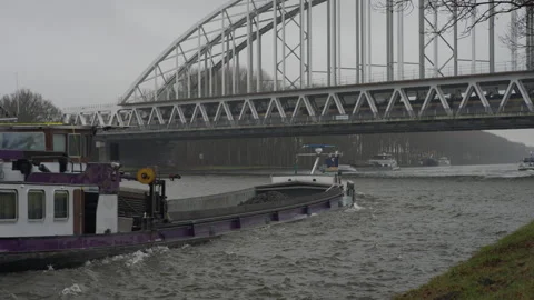 Intermodal Transport: Train crossing bridge while barge sails below 스톡 동영상 328985143