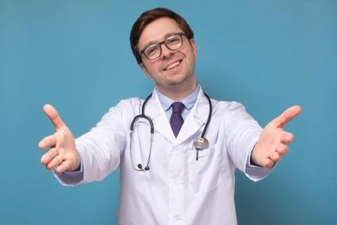 Intern or doctor pulling hands and smiling friendly at camera wanting hug Stock Photos