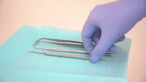 The Intern picks up clean dental instruments on a sterile napkin. Sterilization Video stock 104510378