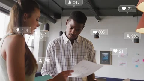 Intern pointing at green folder and man studying paper, sparking social icons Stock Footage 331349865