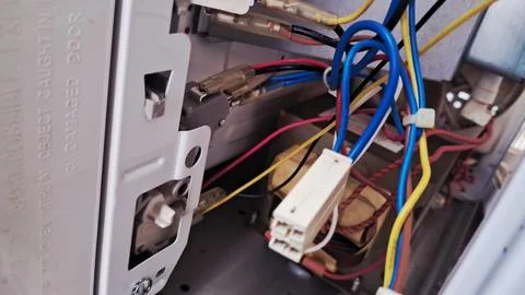 Internal electrical wiring components inside an open white microwave oven Stock Photos