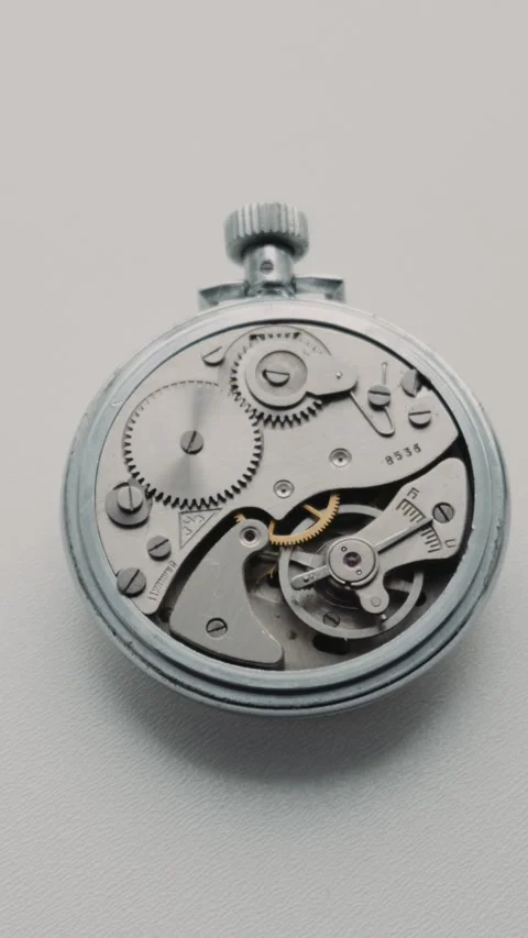 Internal Mechanism Of Silver Stopwatch Rotating Slowly On White Surface Stock Footage 330267136