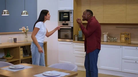An international couple is having a row in the kitchen, in the general plan are Stock Footage 263176029