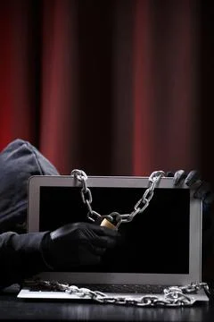 International hacker in black pullover and black mask trying to hack governme Stock Photos