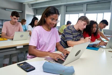 International students in class using laptop to work, concentrated studying with Stock Photos