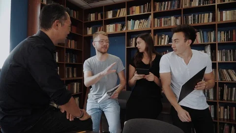 International students working on a project in a group, discussing their Stock Footage 98555839