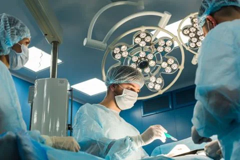 An international team of doctors performs a complex surgical operation on a Stock Photos