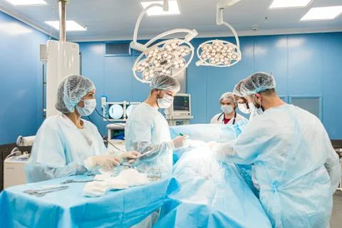 An international team of doctors performs a complex surgical operation on a Stock Photos