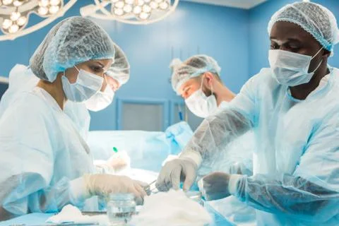 An international team of doctors performs a complex surgical operation on a Stock Photos