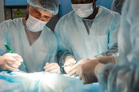 An international team of doctors performs a complex surgical operation on a Stock Photos