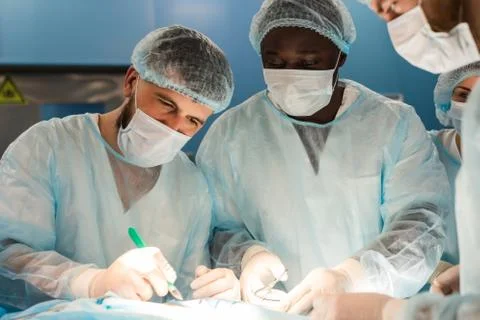 An international team of doctors performs a complex surgical operation on a Stock Photos