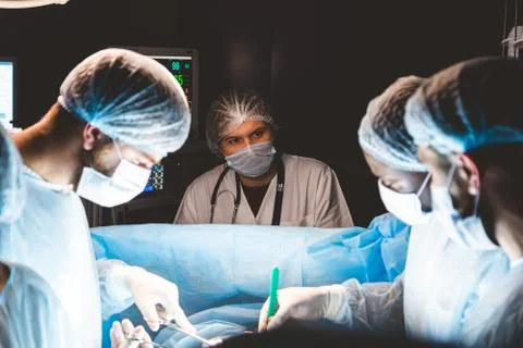 An international team of doctors performs a complex surgical operation on a Stock Photos